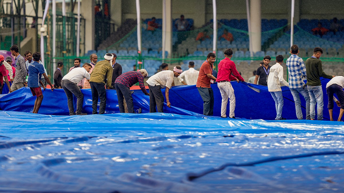 Ground staff remove covers off the field before the start of play. PTI Photo
