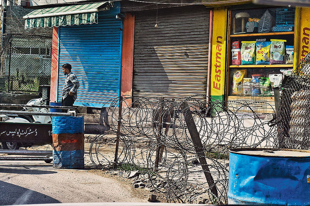 Photo: Yasir Iqbal : Sights of Silence: A man standing next to a checkpoint in downtown Srinagar