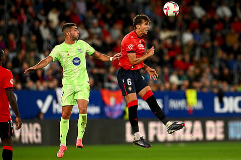 La Liga 2024-25, Osasuna and Barcelona: Barcelona's Ferran Torres jumps for the ball against Osasuna's Lucas Torro 