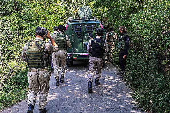 Indian Army, JK Police, and CRPF personnel rush towards the site where an encounter breaks out between security forces and militants at Check Kreeri Pattan in Baramulla, Jammu and Kashmir, India, on September 14, 2024.