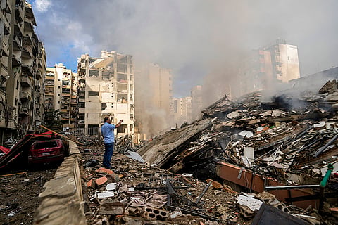 Mideast Tensions: A man documents the damaged buildings in Beirut's southern suburb