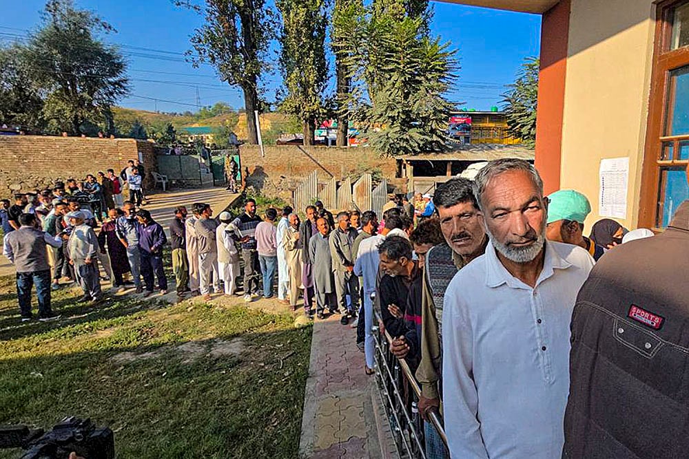 Voters wait in a queue 
 to vote during Jammu and Kashmir Assembly polls