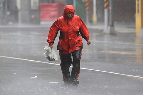 Taiwan Typhoon Krathon: A woman struggles in the wind and rain