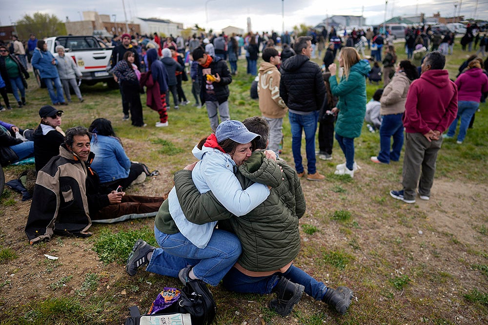 People embrace during an annular solar eclipse in Puerto San Julian