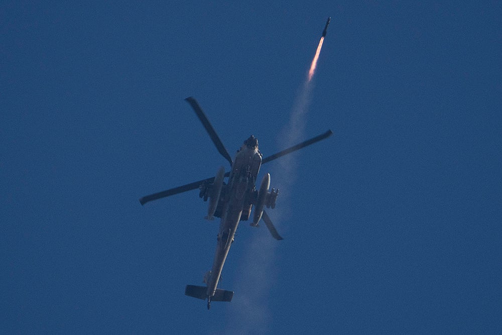 | Photo: AP/Leo Correa : Mideast Tensions: An Israeli Apache helicopter fires a missile towards Lebanon