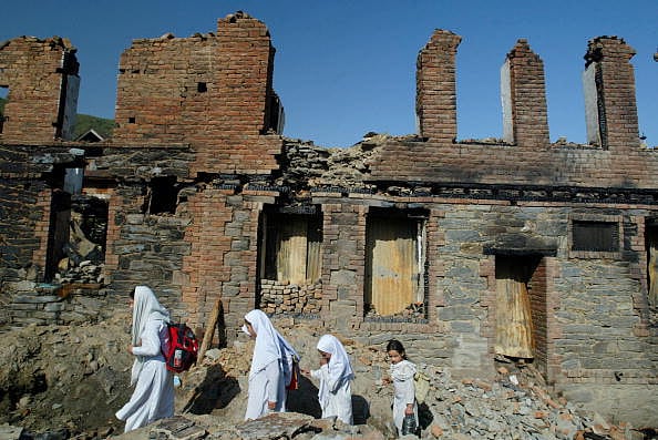 Getty Images : Students walk home past burned homes June 10, 2002 in Baramulla