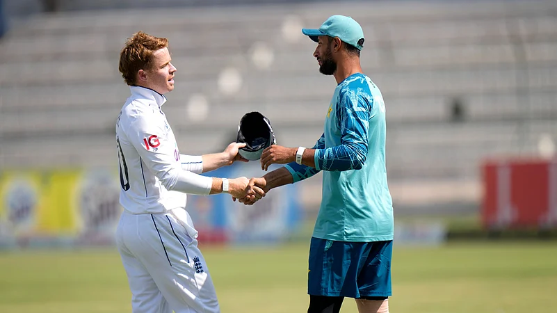 Englands Ollie Pope, left, shakes hand with Pakistans Shan Masood. AP Photo