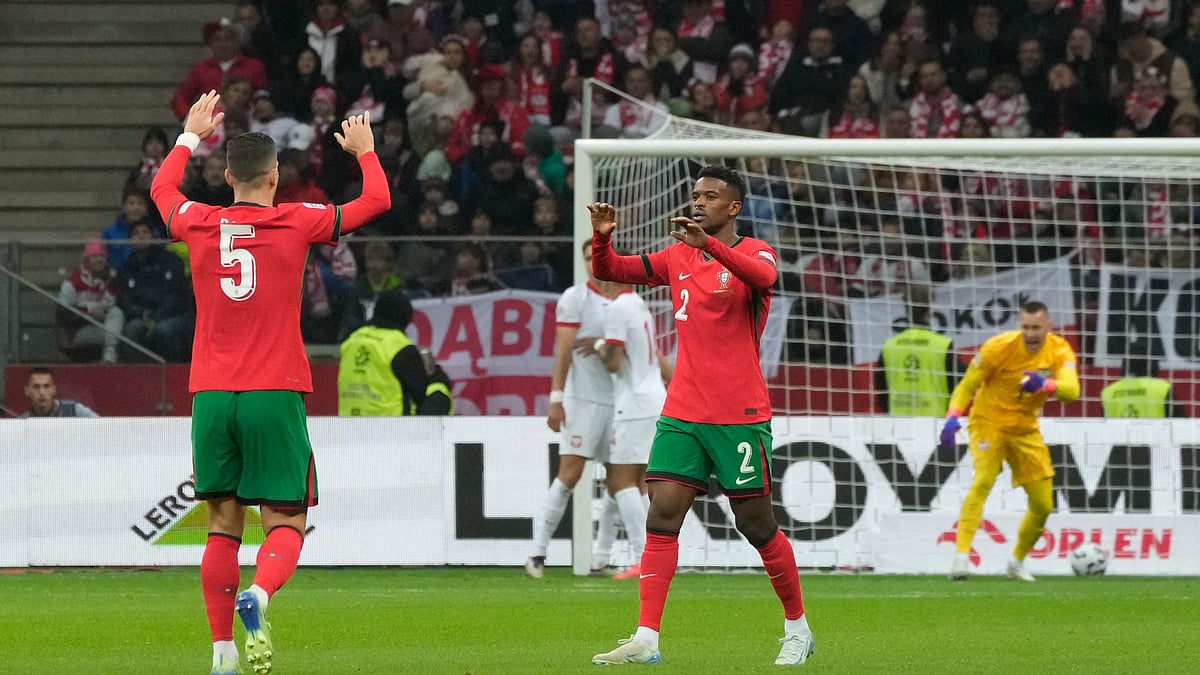 AP Photo/Czarek Sokolowski : Portugal's Diogo Dalot, left, and Nelson Semedo celebrate after Poland's Jan Bednarek scored own goal during the UEFA Nations League soccer match between Poland and Portugal at Narodowy stadium in Warsaw.