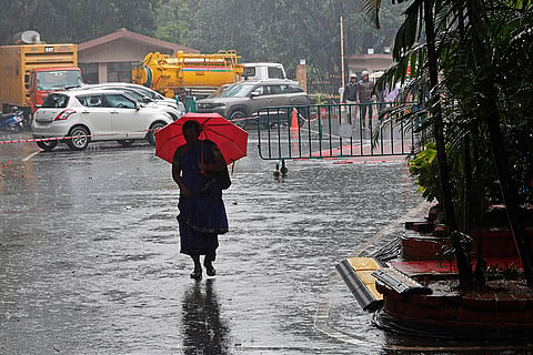 IND Vs NZ 1st Test: A woman walks inside the premises of the M.Chinnaswamy Stadium as it rains