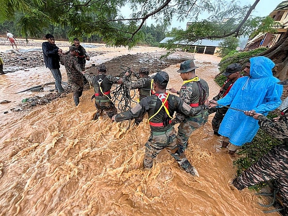  Army officials, emergency teams and civilians help rescue people at the disaster site in Wayanad.