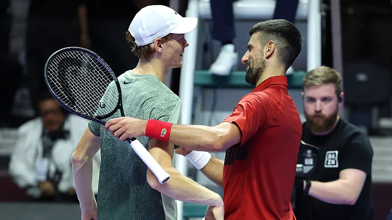 Jannik Sinner greets Novak Djokovic after winning match point. - null
