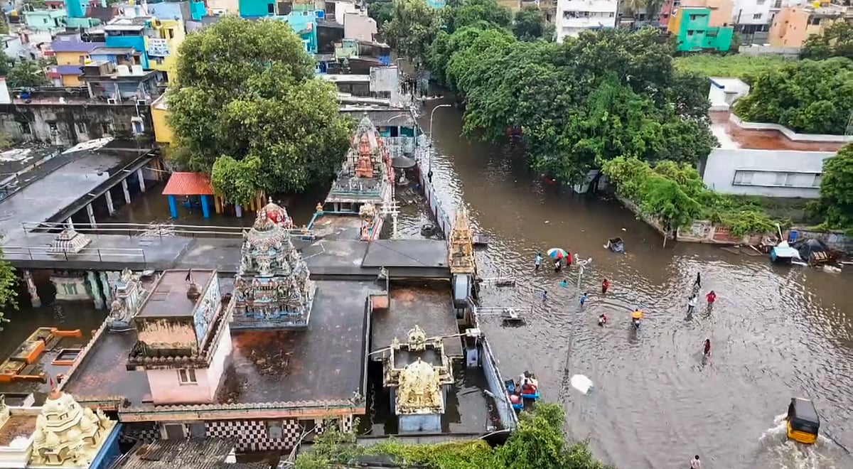 PTI : Commuters wade through a waterlogged area after heavy rainfall, in Chennai, Wednesday, Oct 16