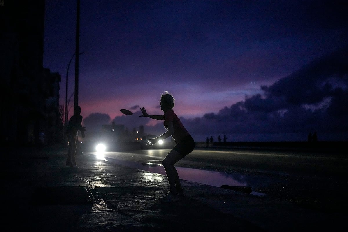 AP : A woman prepares to catch a tossed frisbee during a massive blackout after a major power plant failed in Havana | 