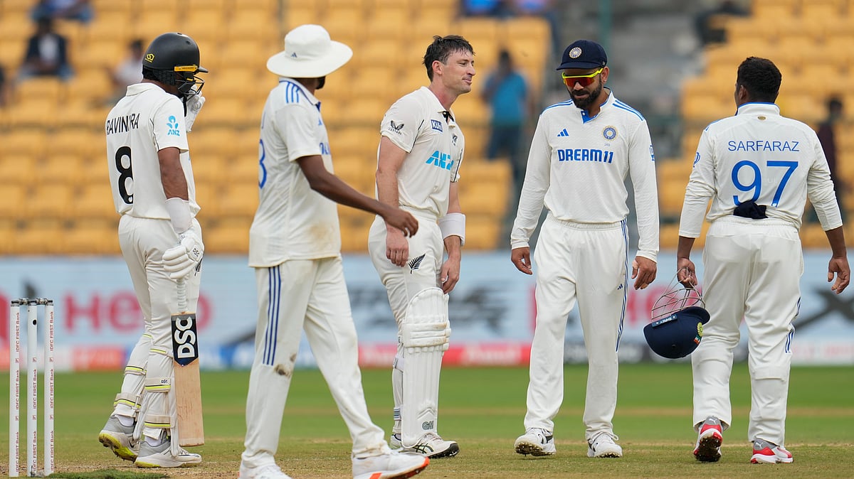 New Zealand's Will Young, centre, interacts with Indian players after the ball hit on his helmet on a delivery by India's Ravindra Jadeja during the day five of the first cricket test match between India and New Zealand at the M.Chinnaswamy Stadium, in Bengaluru. - AP Photo/Aijaz Rahi