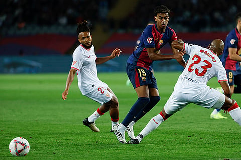 La Liga 2024-25: Barcelona's Lamine Yamal, center, duels for the ball with Sevilla's Marcao