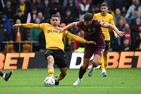 EPL 2024-25: Wanderers' Joao Gomes, left, and Manchester City's Ruben Dias vie for the ball