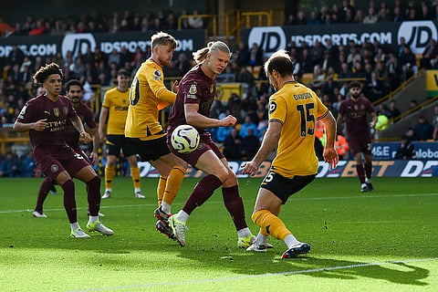 EPL 2024-25: Manchester City's Erling Haaland, center, and Wolverhampton Wanderers' Craig Dawson, right, compete for the ball 