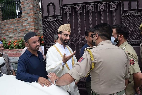 By Waseem Andrabi Hindustan Times via Getty Images : Hurriyat Conference chairman Mirwaiz Umar Farooq being stopped by police personnel outside his residence on August 26, 2022 in Srinagar, India. A week after Lt Governor Manoj Sinha insisted that Mirwaiz Umar Farooq was not under detention, security personnel outside his residence barred him from leaving the premises, saying a security review was still underway. Mirwaiz, chairman of one faction of the Hurriyat Conference was placed under house arrest ahead of Parliament revoking Jammu and Kashmir's special status in August 2019. As he completed three years under house arrest, there were demands from political parties in the Valley that the government should lift the restrictions