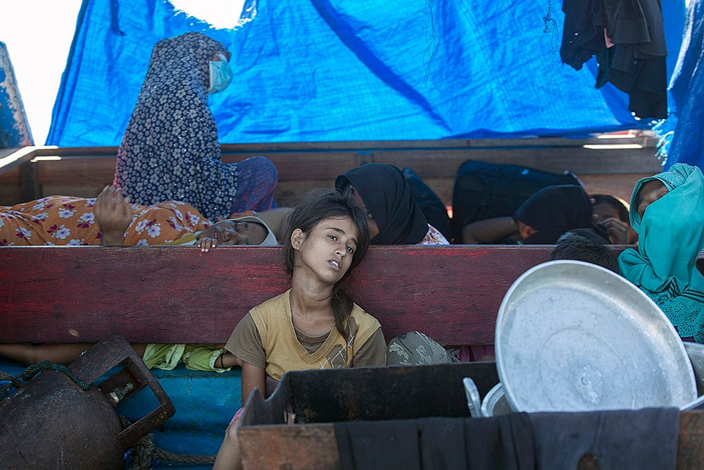 Rohingya refugees : A young Rohingya girl sits on the deck of a refugee boat