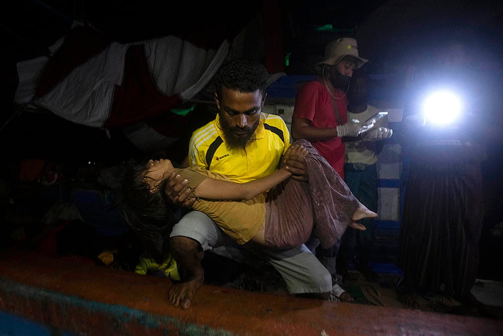 Rohingya refugeeS; A young girl is evacuated from the boat carrying Rohingya Muslims