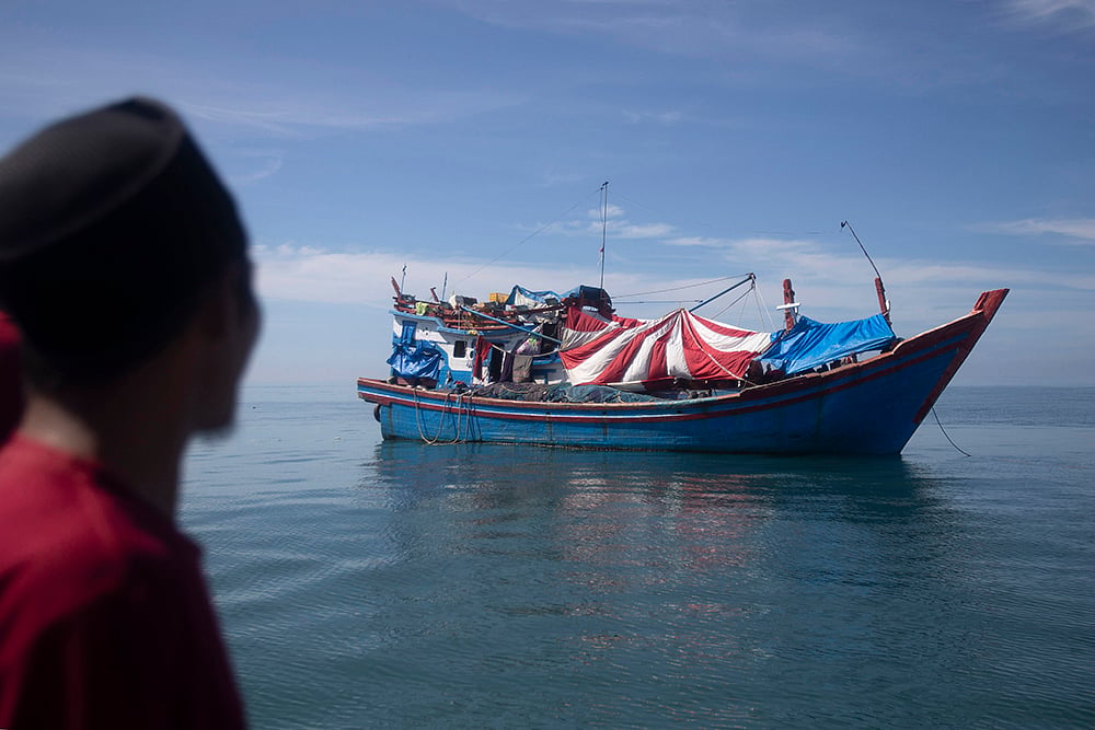 Rohingya refugees: An Acehnese man examines a boat carrying Rohingya Muslims