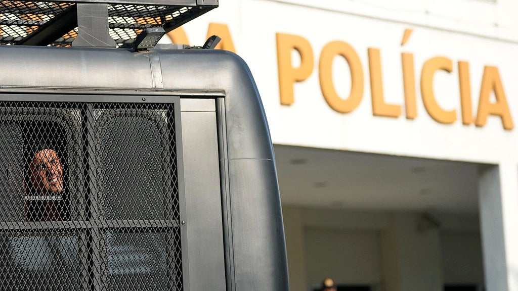 A fan of Uruguay's Penarol team looks out from a police bus upon arriving at a police station after being detained for fighting with police on the beach in Rio de Janeiro, Wednesday, Oct. 23, 2024. - AP