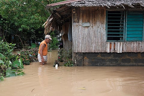 Tropical Storm Trami: A man wades in floods outside his house in Polangui