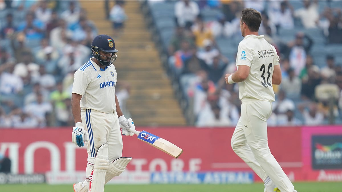 AP Photo/Rafiq Maqbool : New Zealand's Tim Southee, right, celebrates the dismissal of India's captain Rohit Sharma, left, during day one of the second cricket test match between India and New Zealand at the Maharashtra Cricket Association Stadium, in Pune.