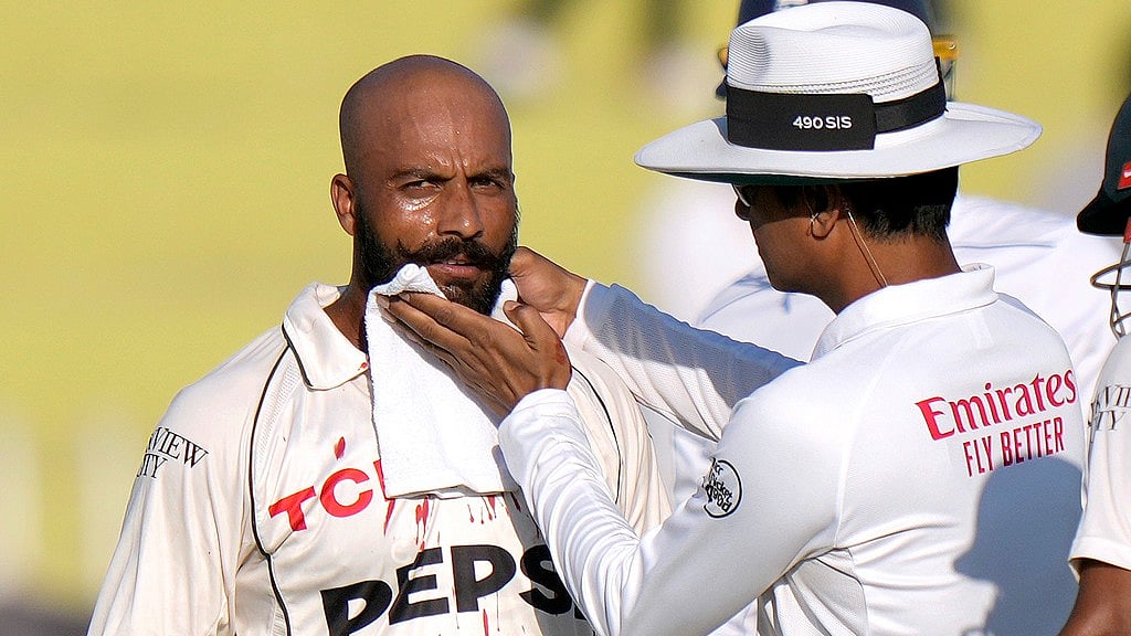 Umpire Sharfuddoula, right, wipes the blood off Sajid Khan's chin after the latter was hit by a ball during the day two of third Test between Pakistan and England in Rawalpindi. - AP/Anjum Naveed