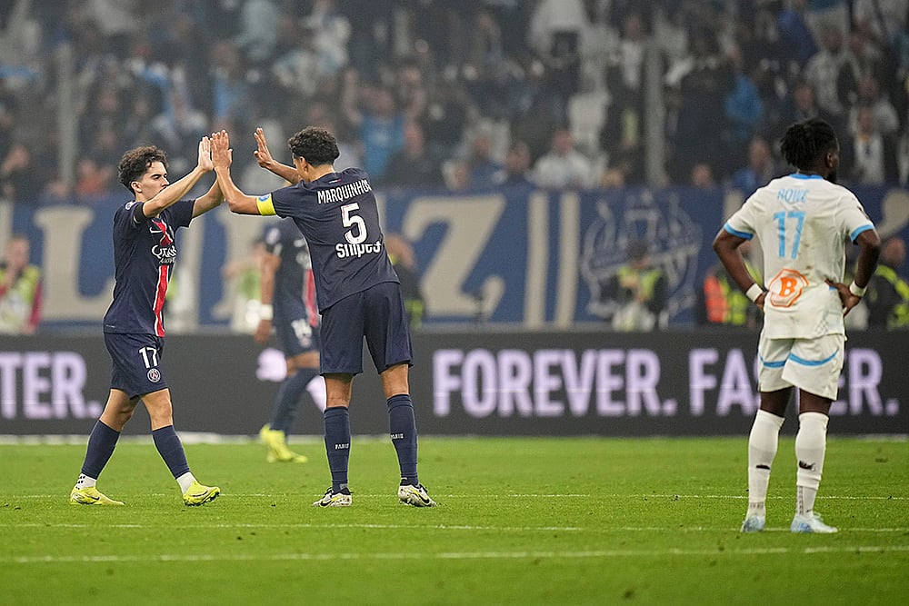 | Photo: AP/Laurent Cipriani : Ligue 1 Soccer 2024-25: PSG's Marquinhos and PSG's Vitinha celebrate winning against Marseille
