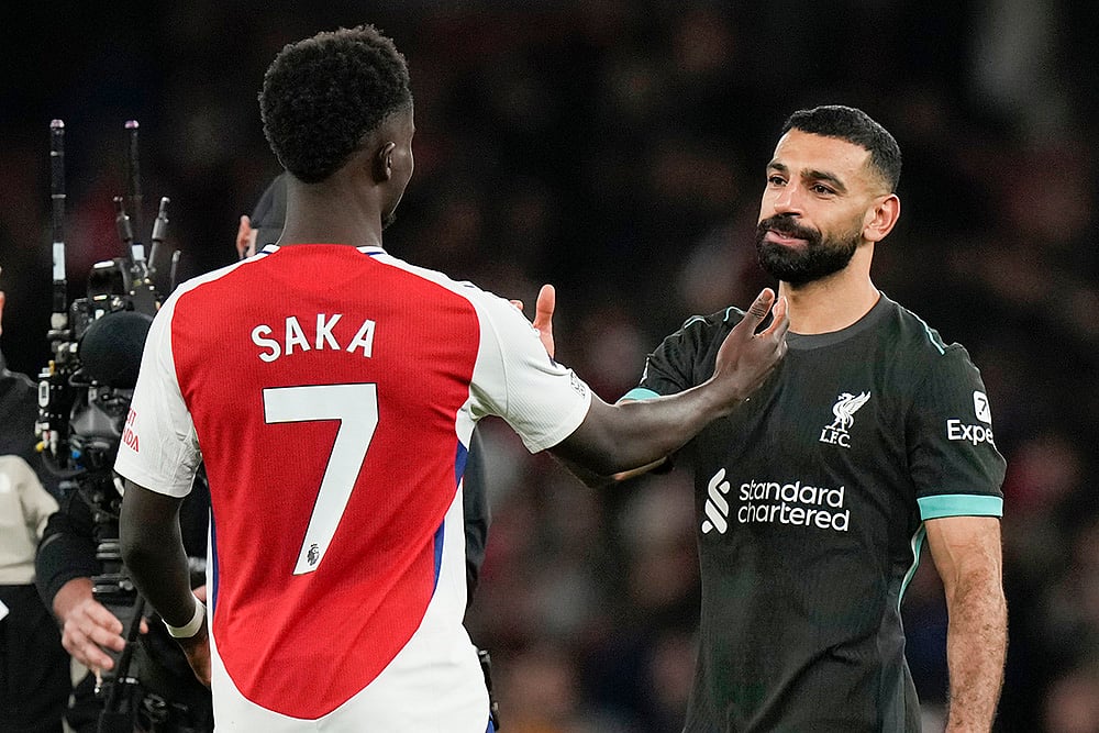 | Photo: AP/Alastair Grant : Premier League 2024-25: Arsenal's Bukayo Saka, left, greets Liverpool's Mohamed Salah