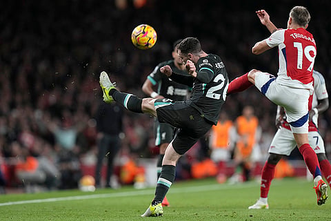 Premier League 2024-25: Liverpool's Andrew Robertson, centre, kicks the ball ahead of Arsenal's Leandro Trossard