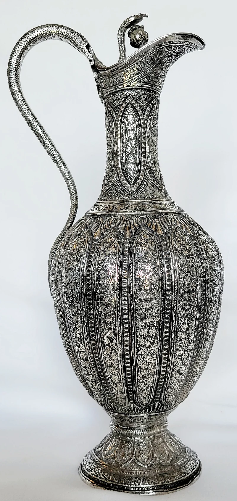 An intricately carved and embossed solid silver Surahi. Mid to late 1800s.