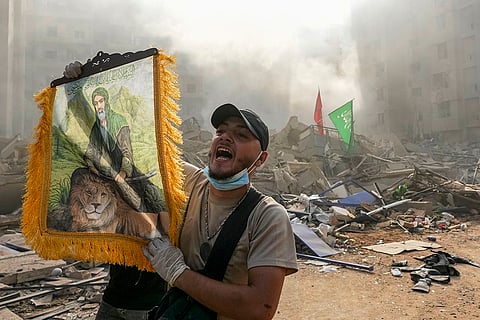 A man shouts slogans as he holds a picture depicting Imam Ali