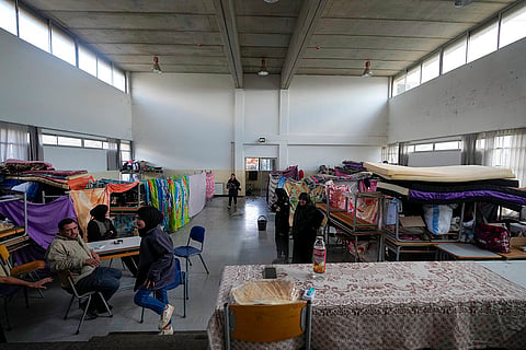 Displaced people sit at a school being used as a shelter