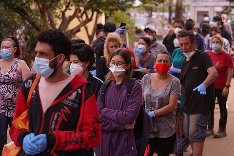 Spain Floods: People queue outside a school used as a distribution centre