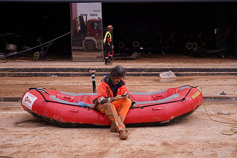 Spain Floods: A firefighter sits on a dingy 