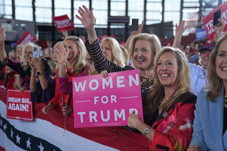 Women for Republican presidential nominee former President Donald Trump show their support as he arrives to speak during a campaign rally at J.S. Dorton Arena, Monday, Nov. 4, 2024, in Raleigh, N.C. - AP Photo/Evan Vucci