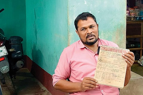 Samajuddin Ansari holding up his land records