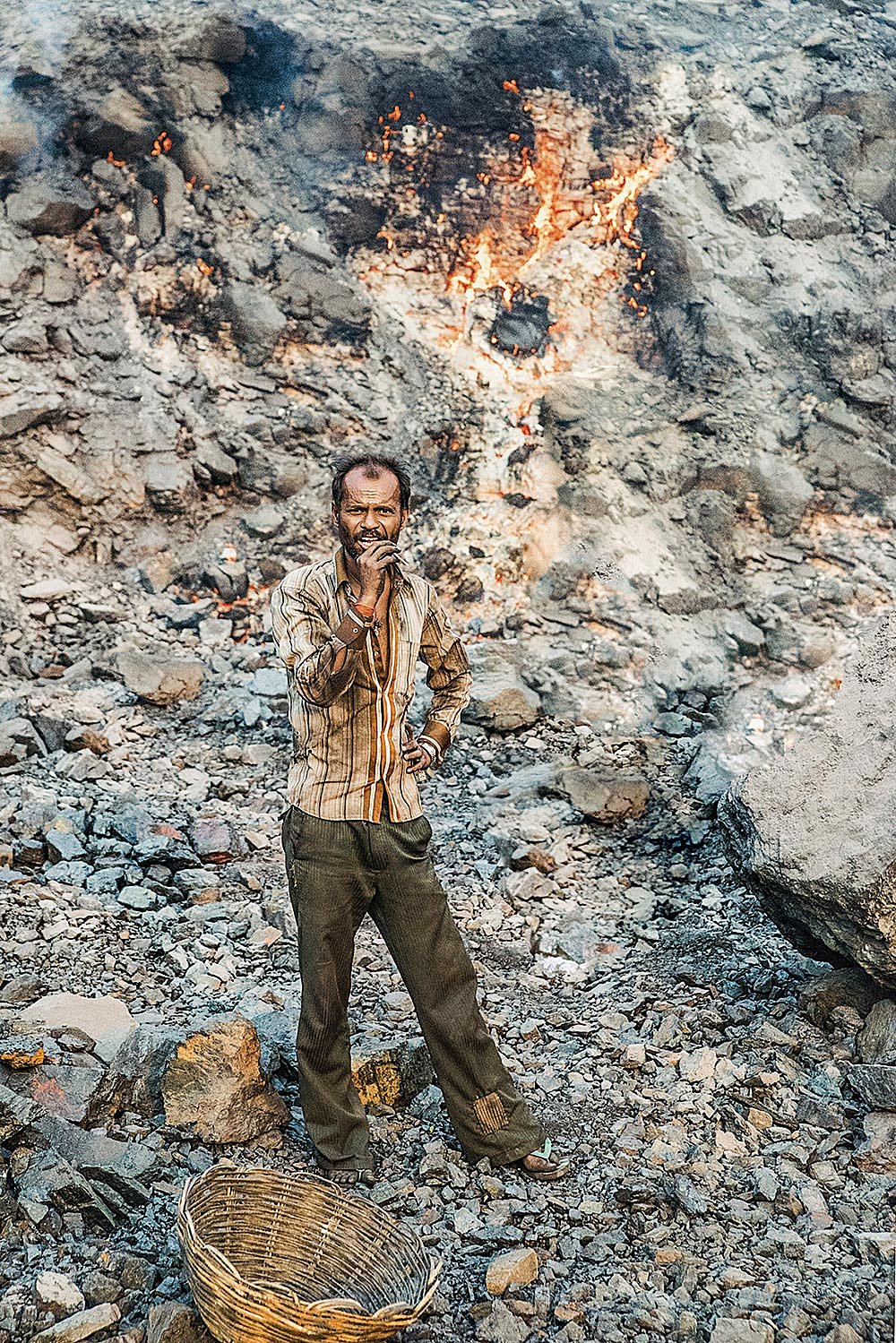 A miner standing in an open coal mine