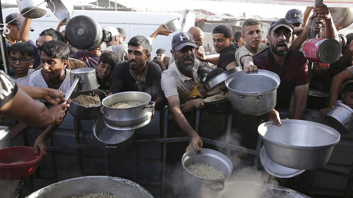 AP : Palestinian men collect food aid ahead of the upcoming Eid al-Adha holiday in Khan Younis, Gaza Strip, on June 15, 2024.