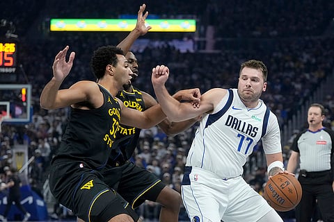 NBA Cup: Mavericks guard Luka Doncic (77) drives to the basket against Warriors forward Trayce Jackson-Davis, left, and forward Andrew Wiggins 