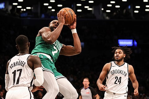 NBA: Celtics' Jaylen Brown drives to the basket while Nets' Dennis Schroder defends