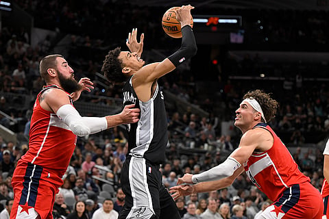 NBA: Spurs' Victor Wembanyama, center, tangles with Wizards' Jonas Valanciunas, left, and Corey Kispert 