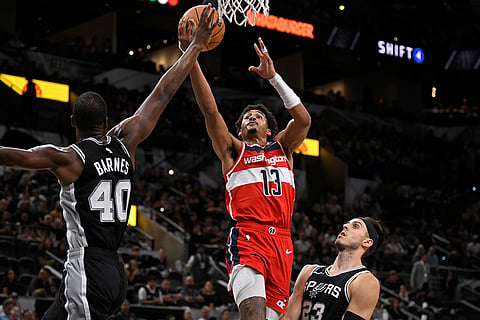 NBA: Wizards' Jordan Poole (13) goes to the basket against Spurs' Harrison Barnes (40) and Zach Collins 