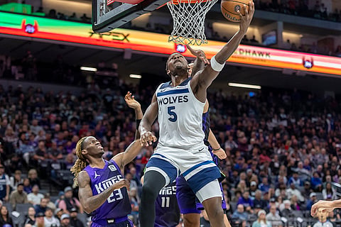 NBA: Timberwolves guard Anthony Edwards (5) makes a reverse layup past Kings forward Trey Lyles