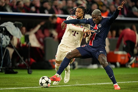 UEFA Champions League: Bayern's Michael Olise, left, duels for the ball with PSG's Nuno Mendes