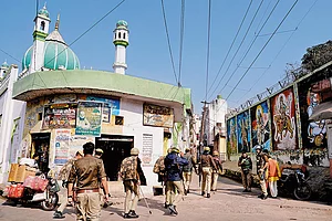 | Photo: Tribhuvan Tiwari : Tense Landscape: Tight security outside a mosque overlooking a wall painted with murals of Hindu deities in Sambhal, Uttar Pradesh