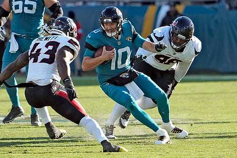Texans vs Jaguars NFL Football: Jaguars quarterback Mac Jones (10) tries to elude Texans linebacker Neville Hewitt 