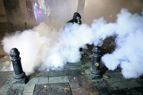 Pro-EU protests in Georgia: A demonstrator walks through a cloud of tear gas
